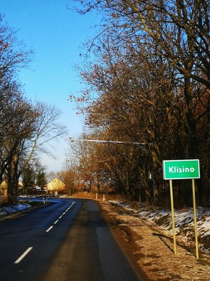 tabliczka z miejscowością Klisino, w oddali maszt z odcinkowym pomiarem prędkości nad jezdnią
